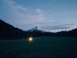 car driving trough valley with lamps on Simon Abele