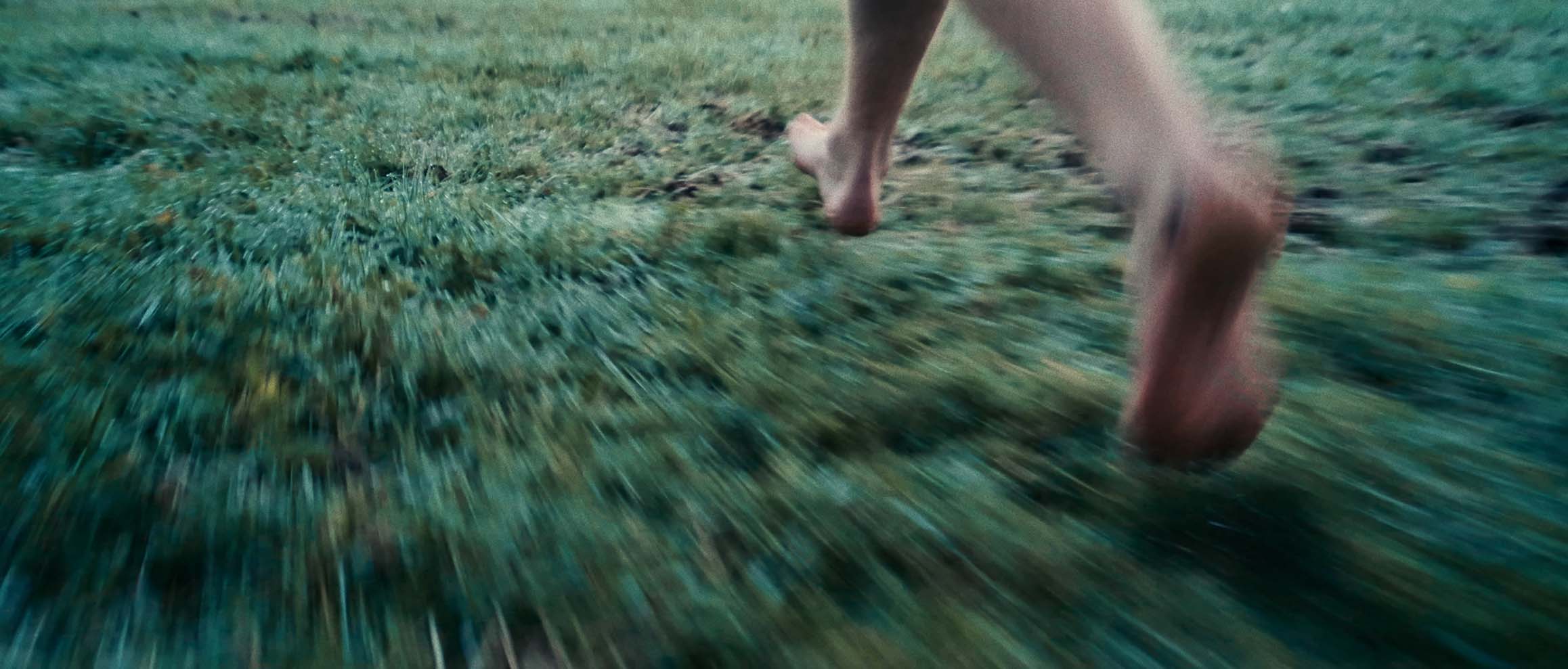 barefoot man running trough gras Simon Abele